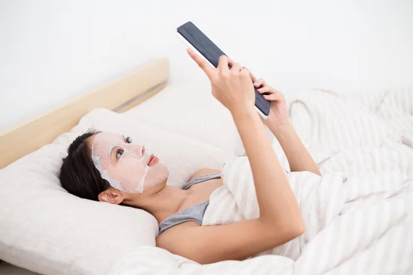 Wanita dengan masker wajah menggunakan pc tablet — Stok Foto