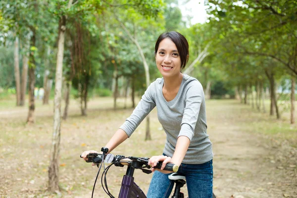 Woman riding bicycle in park — Stock Photo, Image