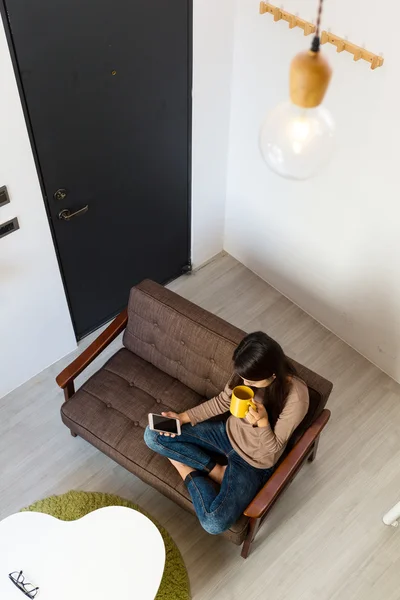 Mujer usando el teléfono celular y beber té — Foto de Stock