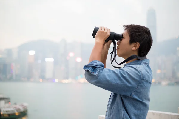 Mann blickt mit Fernglas auf Hongkong — Stockfoto