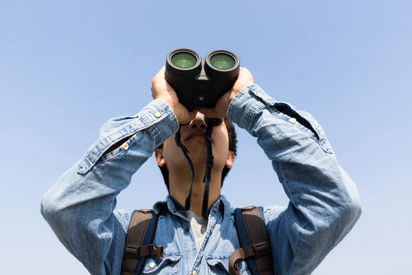 Mladý muž pomocí dalekohledu — Stock fotografie