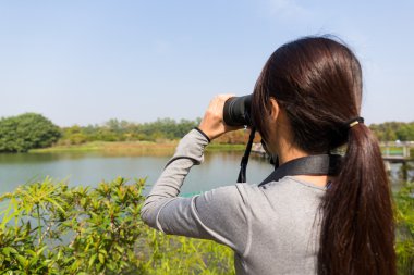 açık havada, dürbün ile arayan kadın