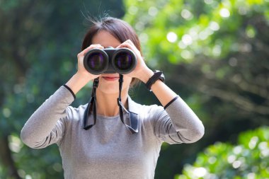 açık havada, dürbün ile arayan kadın