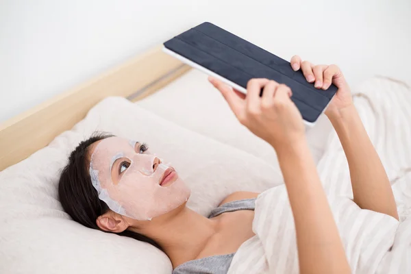 Wanita menggunakan masker wajah dan pc tablet — Stok Foto