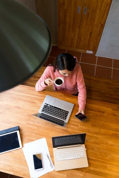 Vrouw drinken koffie en het gebruik van mobiele telefoon — Stockfoto