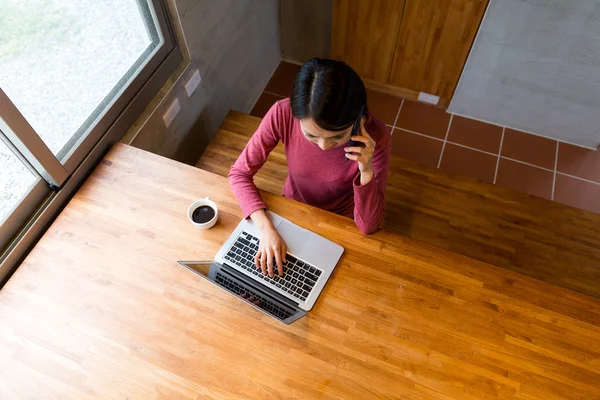 Vrouw met behulp van smartphone en notitieboekjecomputer — Stockfoto