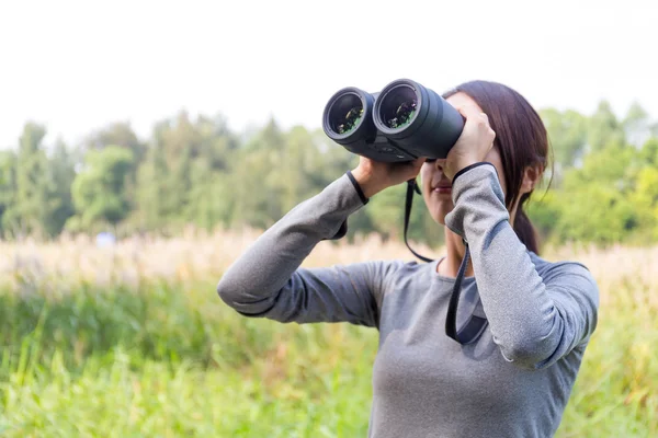 Aziatische vrouw kijken hoewel verrekijkers — Stockfoto