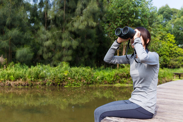 Asian woman watching though binoculars