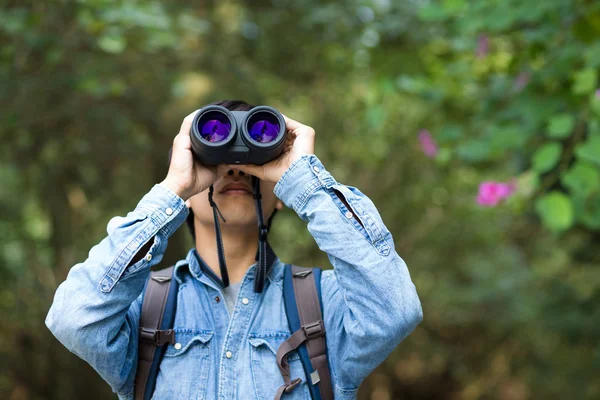 Jovem homem uso do binocular na floresta — Fotografia de Stock