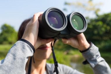 woman looking through binoculars at outdoors clipart