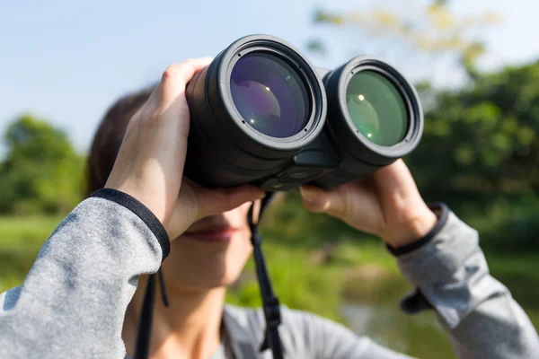 Žena při pohledu dalekohledem v přírodě — Stock fotografie