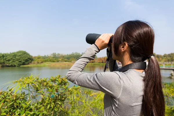 Mulher olhando através de binóculos ao ar livre — Fotografia de Stock