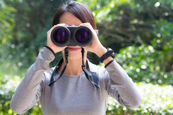 Mulher usando binóculos na floresta — Fotografia de Stock