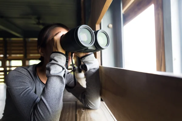 Азиатка использует бинокль для наблюдения за птицами — стоковое фото