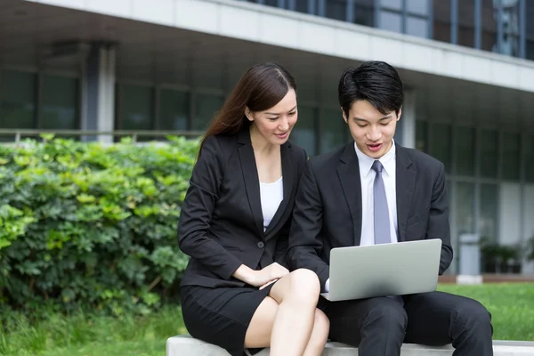 Businesswoman and businessman using laptop — Stock Photo, Image