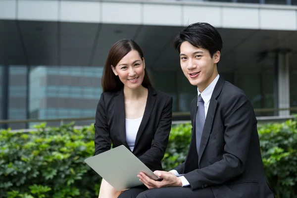 Businesswoman and businessman using laptop — Stock Photo, Image