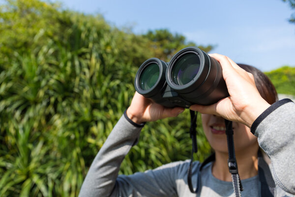 woman looking through binoculars at outdoors