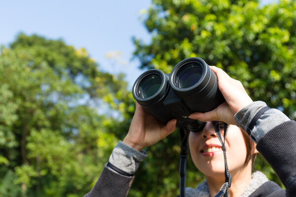 woman looking through binoculars at outdoors