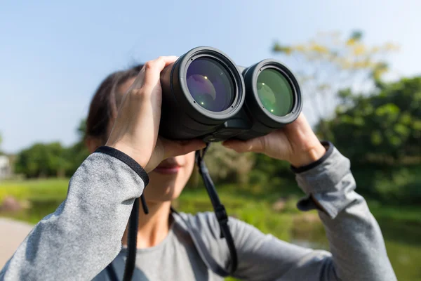 Kvinnan tittar genom kikare på utomhus — Stockfoto