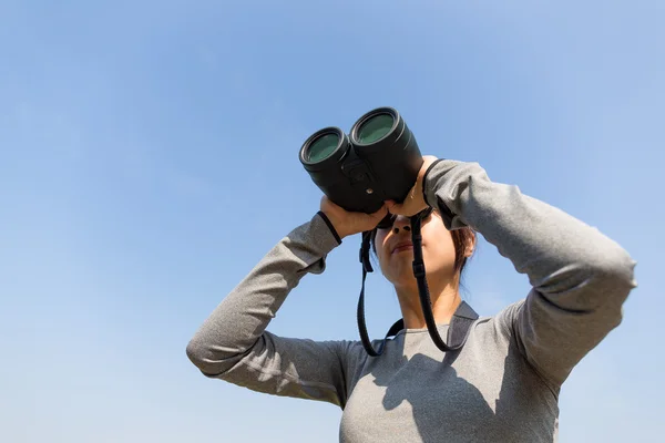 Kvinnan tittar genom kikare på utomhus — Stockfoto