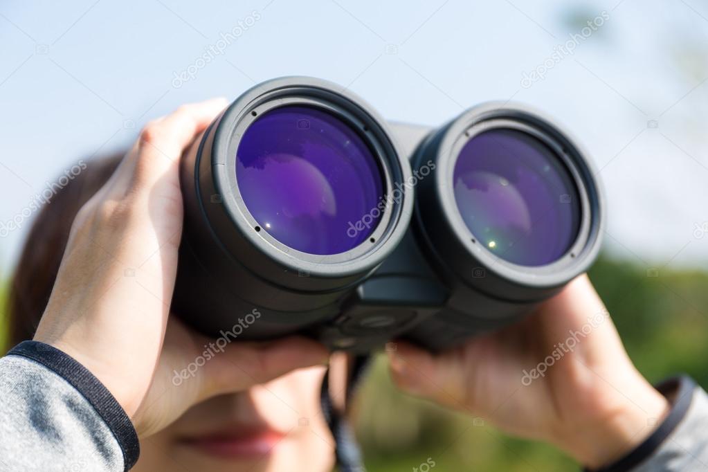 woman looking through binoculars at outdoors