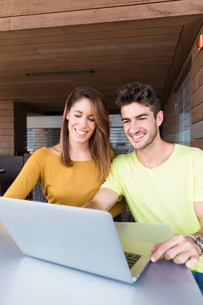 Casal usando computador portátil no café — Fotografia de Stock