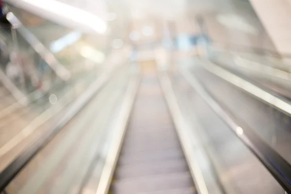 Blur escada rolante no shopping center com bokeh para fundo — Fotografia de Stock