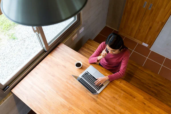 Vrouw praten met cellphone en het gebruiken van laptop — Stockfoto