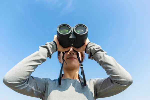 Woman looking though the binocular — Stock Photo, Image