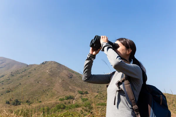 Woman looking though the binocular — Stock Photo, Image