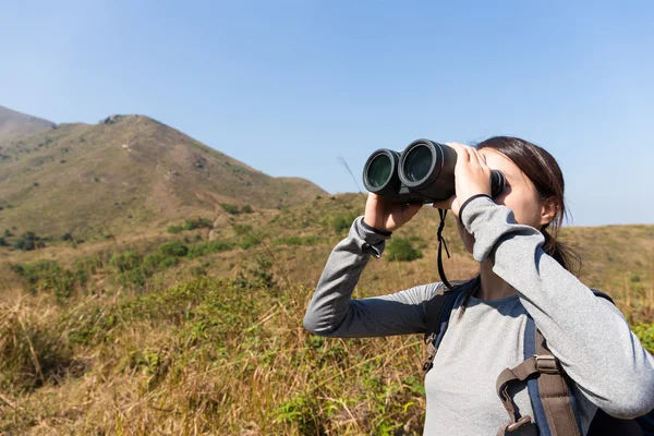 Woman looking though the binocular — Stock Photo, Image