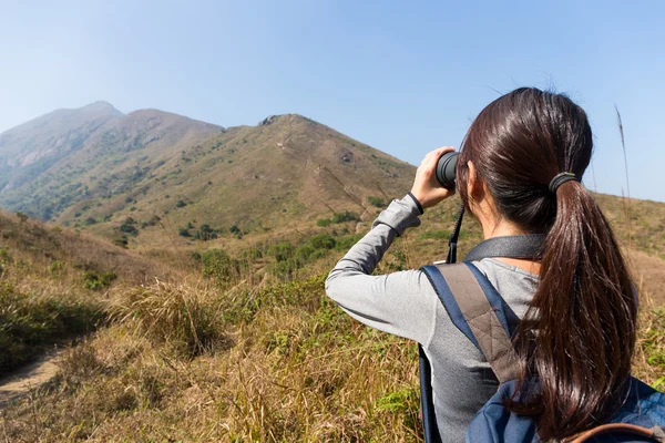 Woman looking though the binocular — Stock Photo, Image