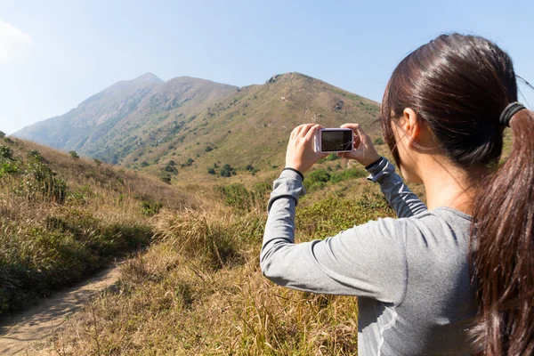 Γυναίκα χρησιμοποιώντας ψηφιακή φωτογραφική μηχανή στα βουνά — Φωτογραφία Αρχείου