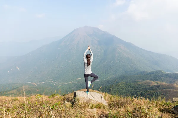 Kvinnan gör yoga på toppen av berget — Stockfoto