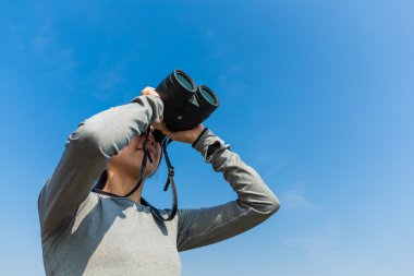 açık havada, dürbün ile arayan kadın