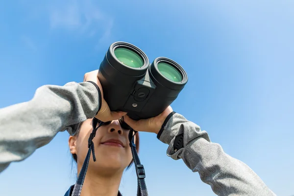 Kvinnan tittar genom kikare på utomhus — Stockfoto