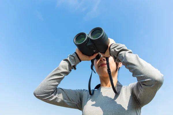 Kvinnan tittar genom kikare på utomhus — Stockfoto