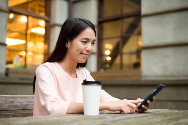 Açık café'de cep telefonu kullanan kadın