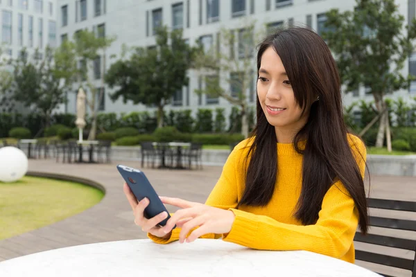 屋外レストランでの携帯電話の若い女性チェック — ストック写真