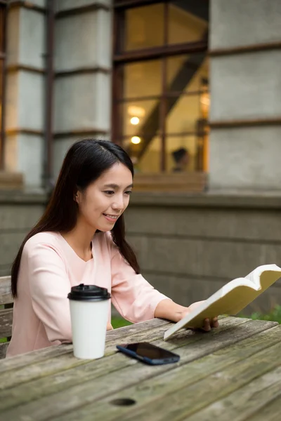 Kvinna läser bok på kafé — Stockfoto