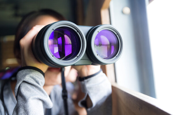 Asian woman using binoculars for birdwatching