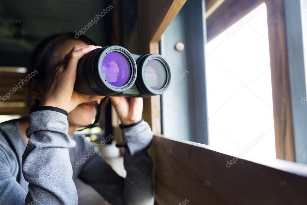 Asian woman using binoculars for birdwatching