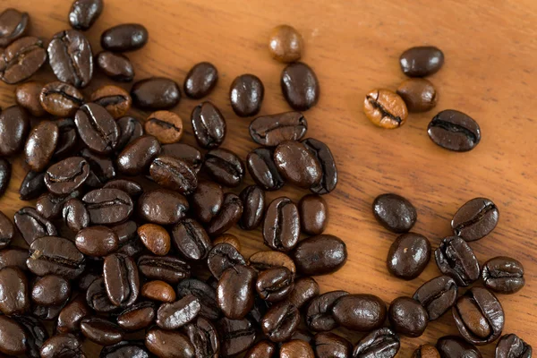 Coffee beans on wooden table — Stock Photo, Image