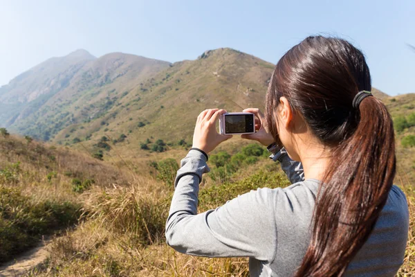 Жінка використовує цифрову камеру в горах — стокове фото
