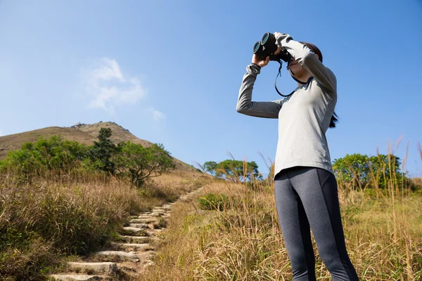 Woman looking though the binocular — Stock Photo, Image