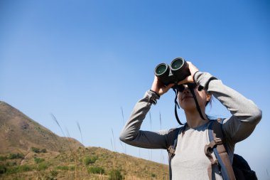 Woman looking though binocular clipart