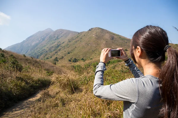 Γυναίκα χρησιμοποιώντας ψηφιακή φωτογραφική μηχανή στα βουνά — Φωτογραφία Αρχείου