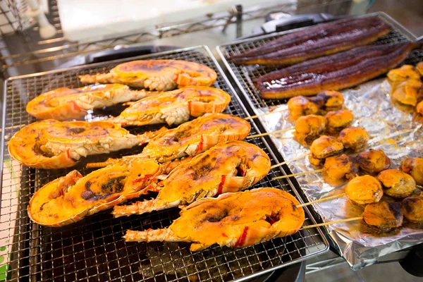 Жареные омары и гребешки на рыбном рынке — стоковое фото