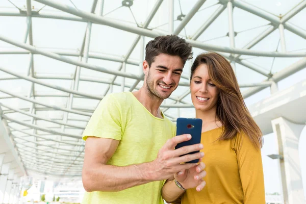 Caucasian couple looking at the mobile phone — Stock Photo, Image
