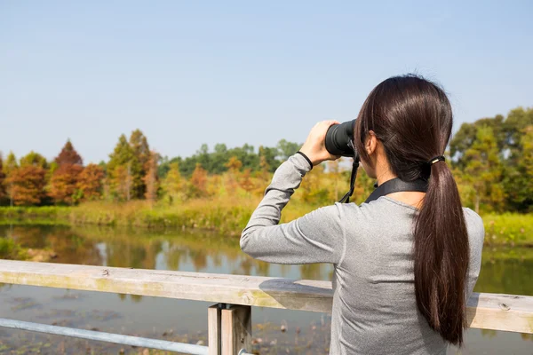 Mulher olhando embora binocular ao ar livre — Fotografia de Stock